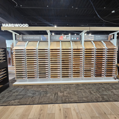 Hardwood flooring display at Modern Flooring America, Kalamazoo, MI, with wood samples, a 'HARDWOOD' sign, and feature highlights like durability and pet-friendliness.